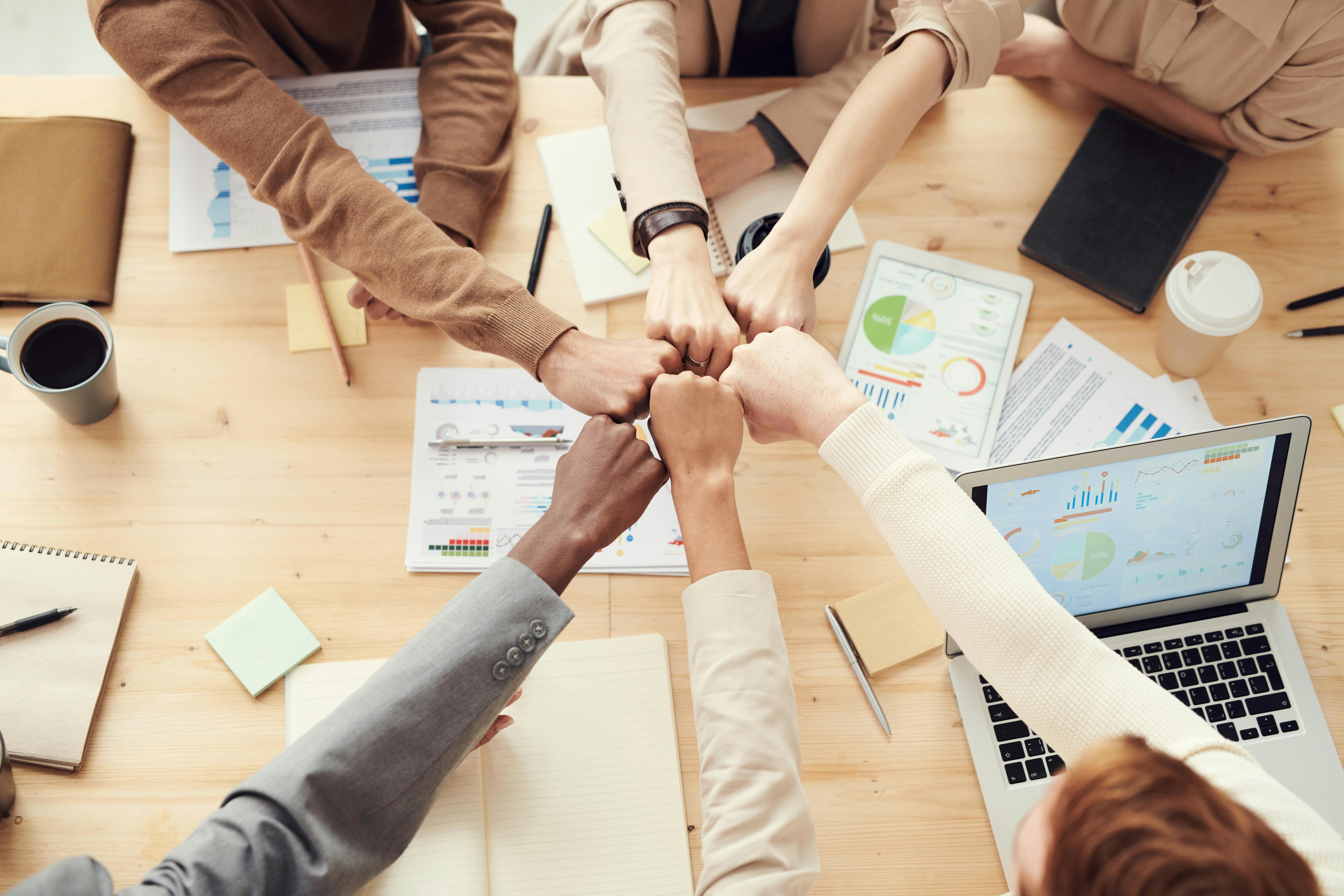 people putting hands together as if to cheer
